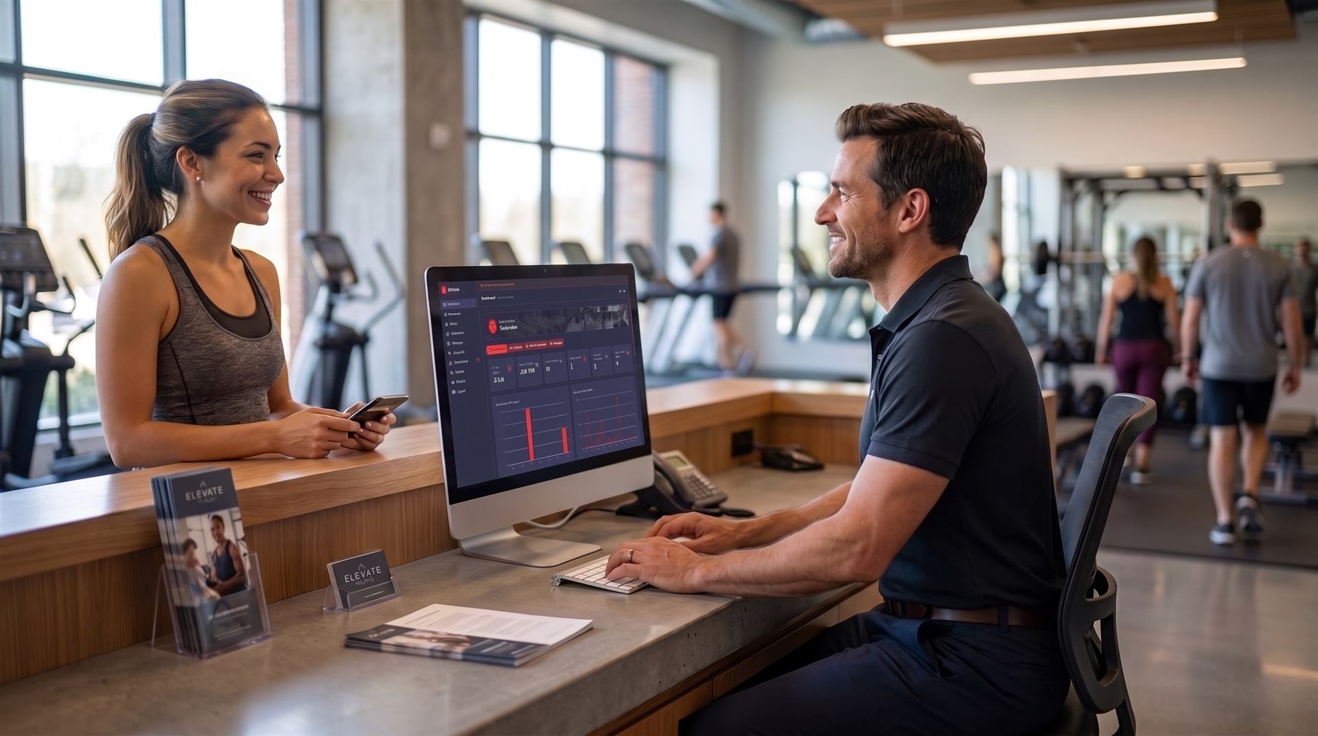 Front desk of a gym, staff checking a member in on GymFlow